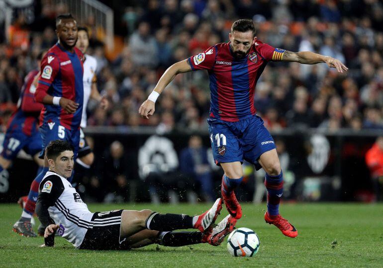 El centrocampista del Levante UD, José Luis Morales (d), se lleva el balón ante el defensa del Valencia CF, Carlos Soler, durante el encuentro correspondiente a la jornada 23 de primera división que disputan esta noche en el estadio valencianista de Mesta