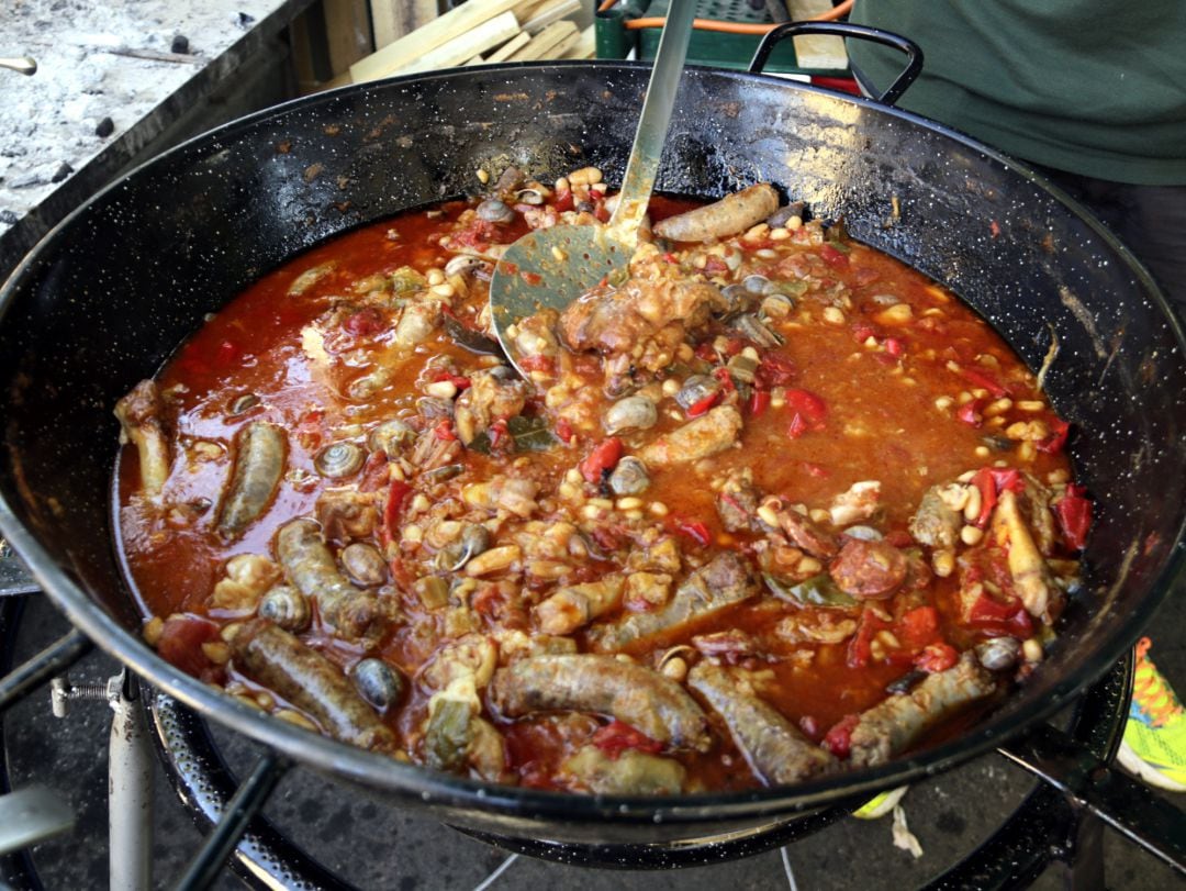 Un cocinero prepara un plato con diferentes tipos de carne blanca. 