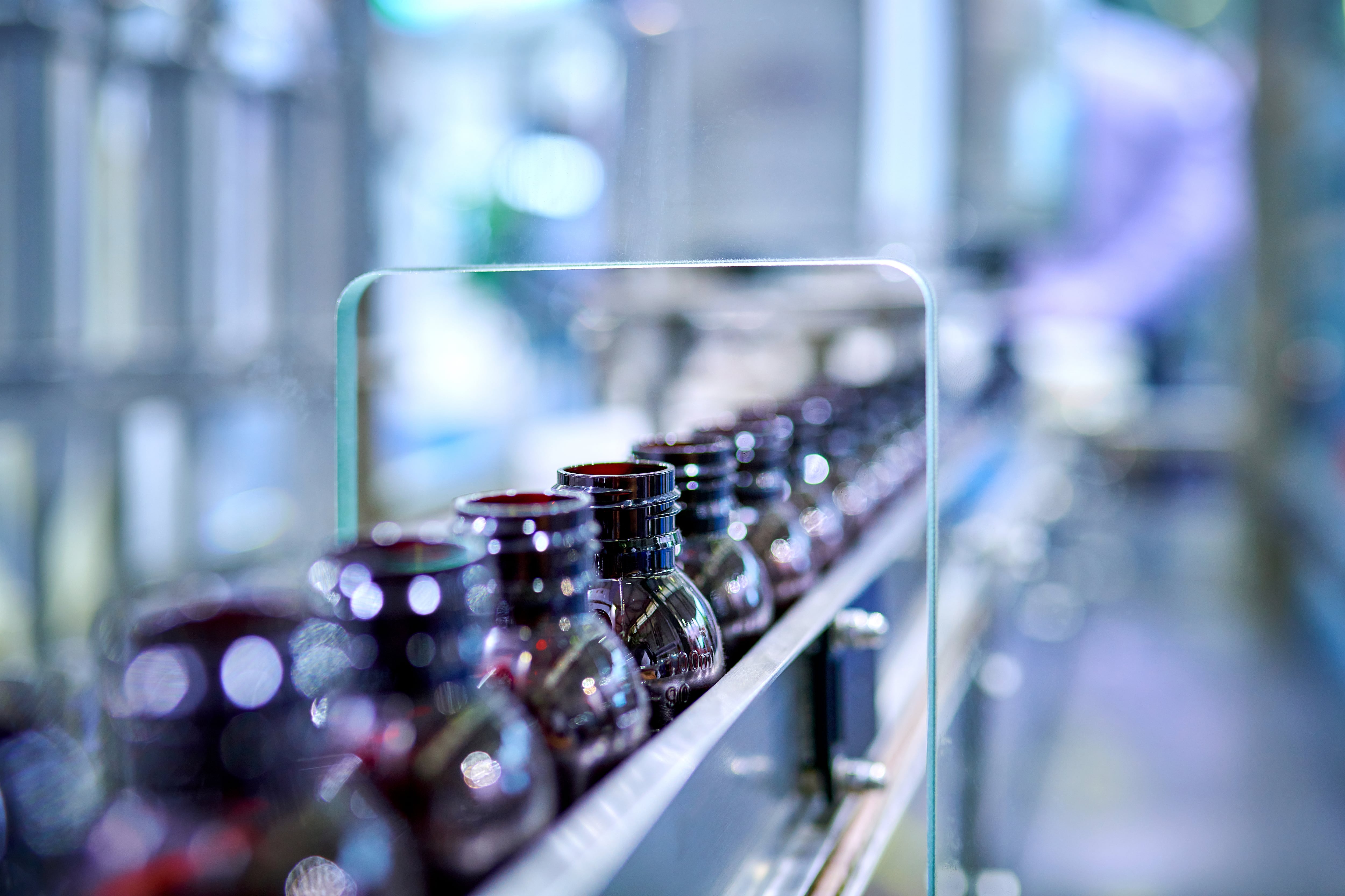 Close-uo of medicine brown glass bottles at production line.