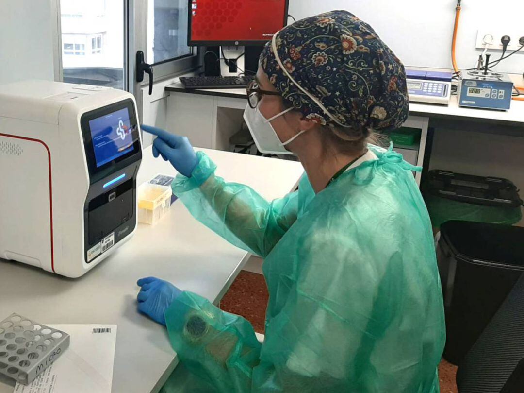 Una sanitaria manipula una máquina involucrada en la gestión de pruebas PCR