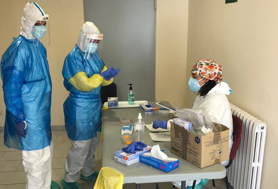 Dos profesionales sanitarios realizan una prueba PCR a una persona.
