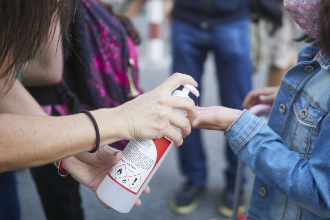 Una profesora desinfecta las manos de una alumna antes de la entrada al Colegio Público Víctor Pradera en el primer día de colegio del curso escolar 2020-2021 en Pamplona, Navarra (España), a 4 de septiembre de 2020