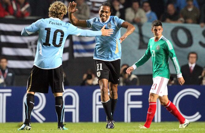 El jugador de la selección de fútbol de Uruguay Álvaro Pereira  festeja su gol a México junto a Diego Forlán en el último partido de la fase de grupos de la Copa América