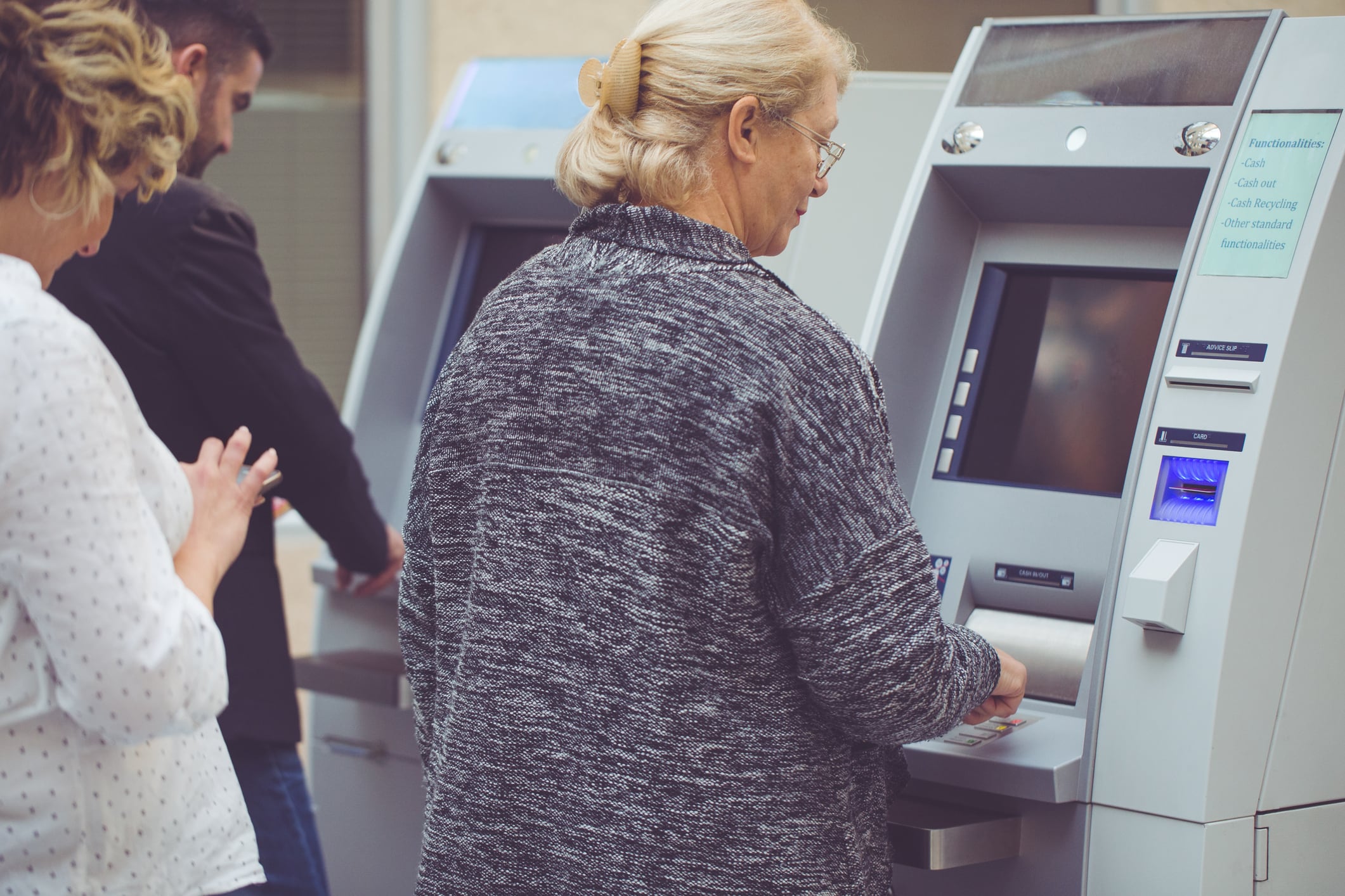 Grupo de personas esperando ser atendidos en un cajero automático