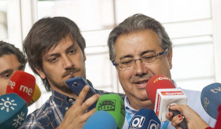 El alcalde de Sevilla y candidato a la reelección, Juan Ignacio Zoido, atiende a los medios de comunicación tras votar en un instituto de Sevilla mientras su hijo ayuda a sujetar un micrófono. EFE/ Raúl Caro