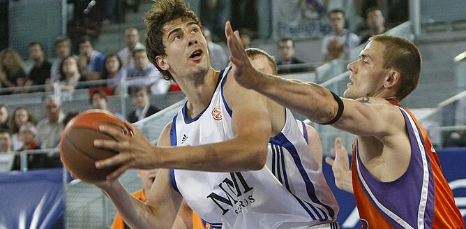 El pívot croata del Real Madrid, Ante Tomic (i), controla el balón ante Robertas Javtokas, pívot lituano del Power Electronic Valencia, durante el quinto y último partido de cuartos de final de la Euroliga de baloncesto que los dos equipos juegan, esta no