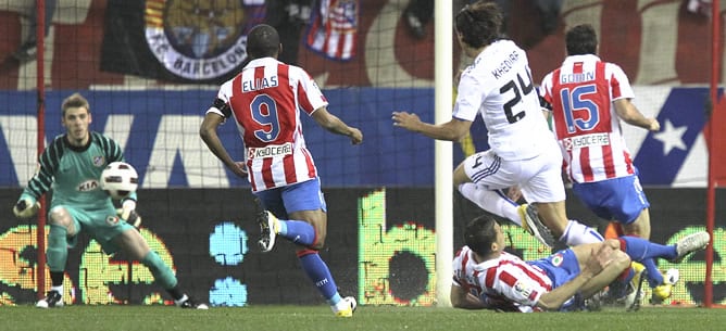 El centrocampista alemán del Real Madrid Sami Khedira chuta a portería presionado por los jugadores del Atlético de Madrid Elías Mendes, Álvaro Domínguez y Diego Godín durante el partido correspondiente a la vigésimo novena jornada de Liga en Primera Divi