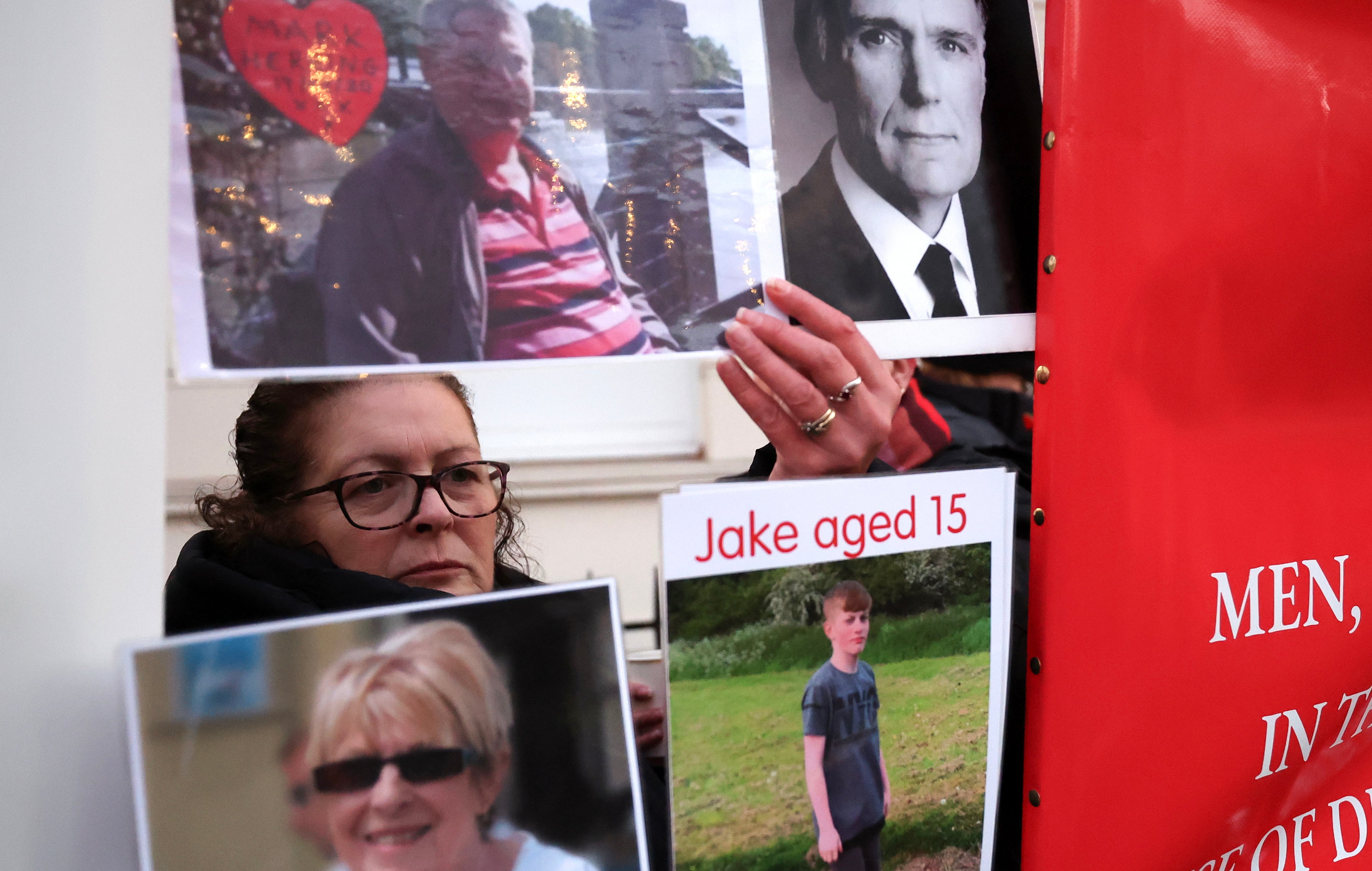 Algunos familiares de las personas fallecidas durante la pandemia de covid sostienen carteles durante la declaración de Boris Johnson.