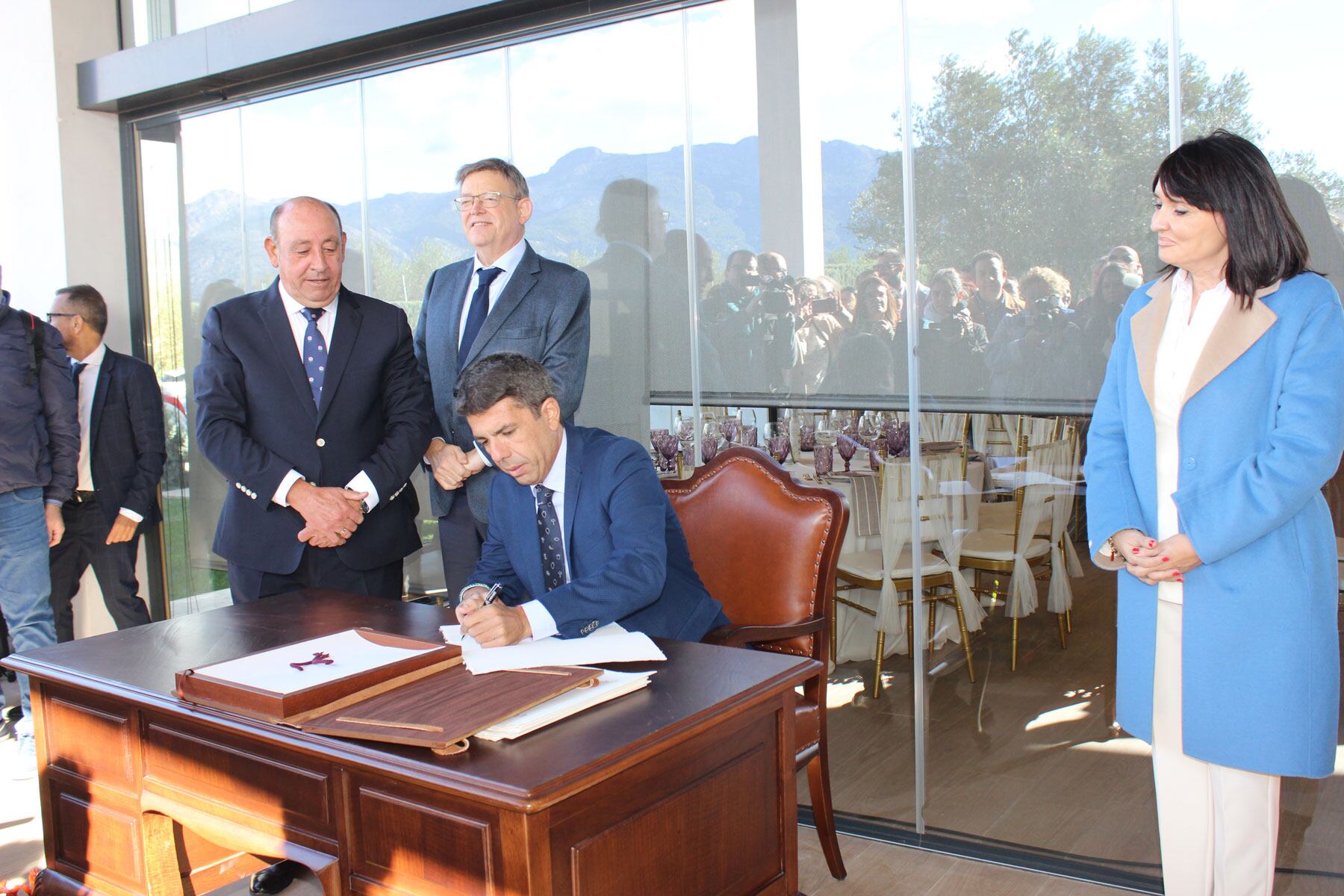 Carlos Mazón, signant en el Llibre d'Or, davant la presència de Julia Parra, Ximo Puig i Jaume Pascual