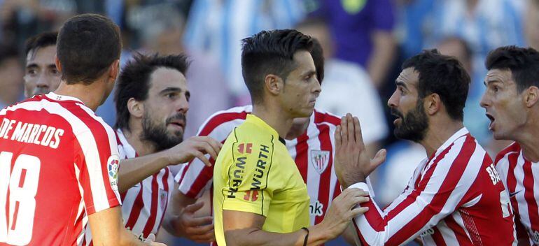 El defensa del Athletic Mikel Balenziaga (d), suplica al arbitro la anulación de su expulsión tras una acción con el defensa venezolano del Málaga Roberto Rosales, durante el partido de la séptima jornada de la liga de Fútbol de Primera División que se ce