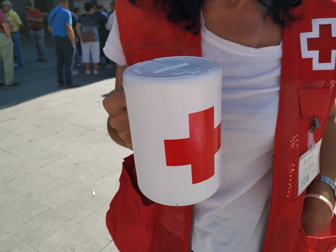 Voluntaria de Cruz Roja con una hucha donde se depositan los donativos