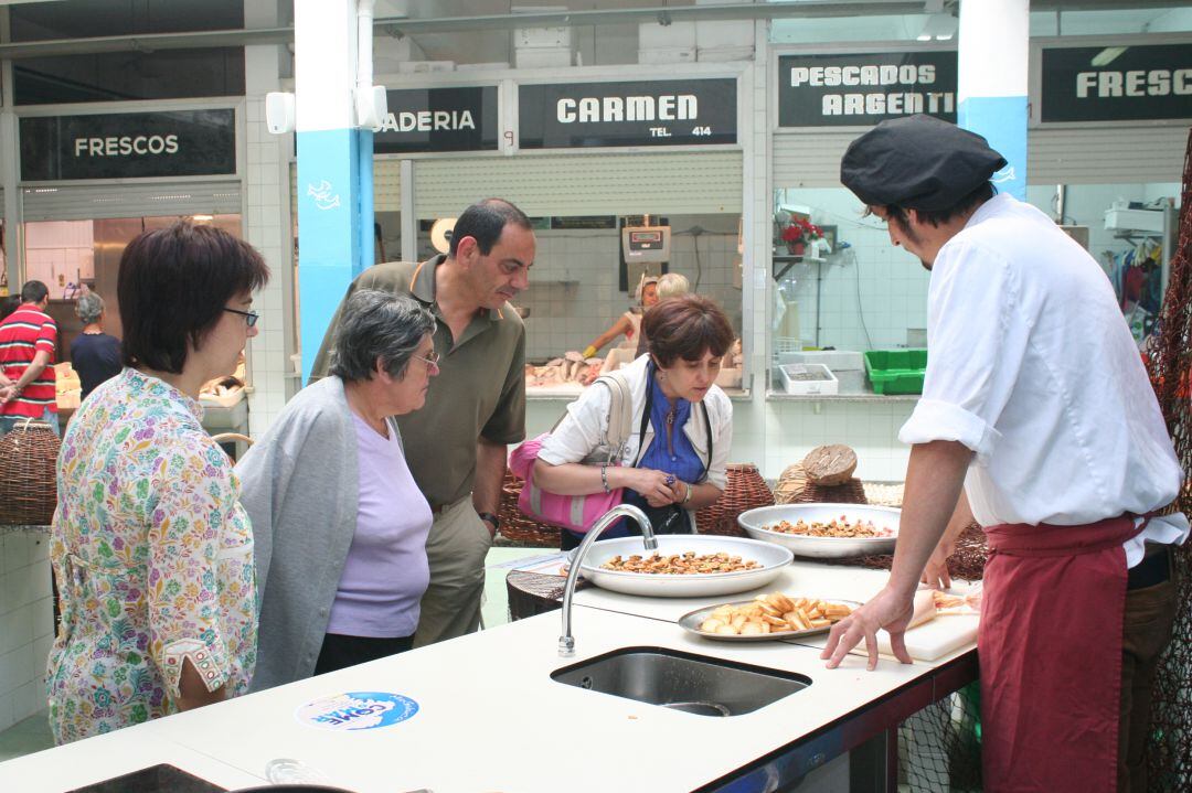 Los concejales Monste Magallanes y Xabier Crespo junto a dos clientas en la Plaza de Abastos.