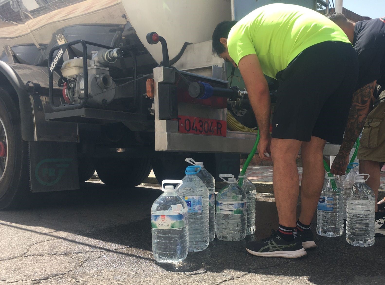 Los vecinos de Peñarroya acuden por la mañana al reparto de agua potable del camión cisterna, el 11 de julio de 2023.