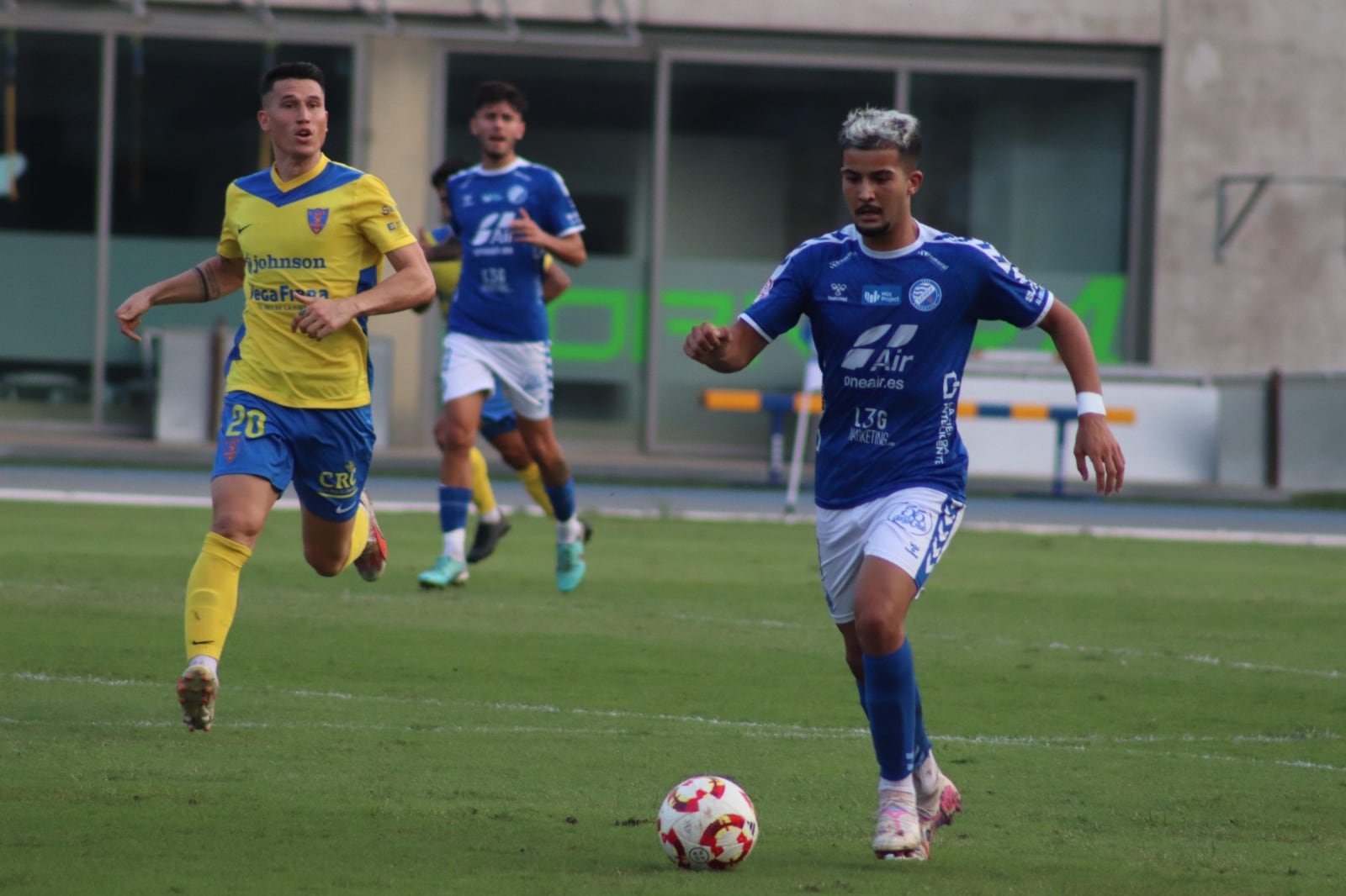 Ilias conduciendo un balón ante un jugador del Orihuela