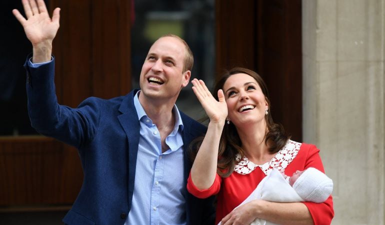 El príncipe Guillermo, duque de Cambridge (i), saluda al lado de su esposa, Catherine (d), duquesa de Cambridge, que sostiene a su hijo recién nacido este lunes.