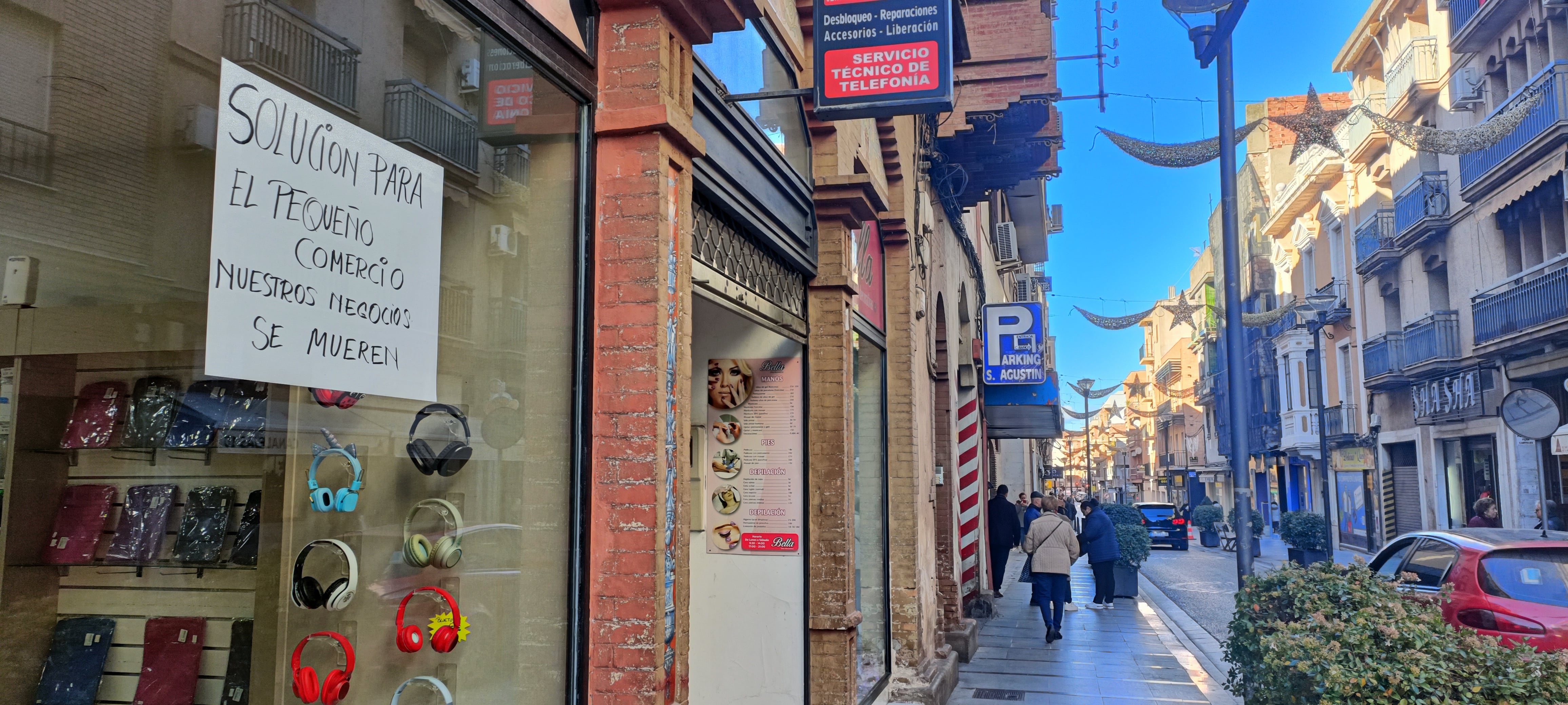 Carteles de comerciantes en calle Canalejas de Linares.