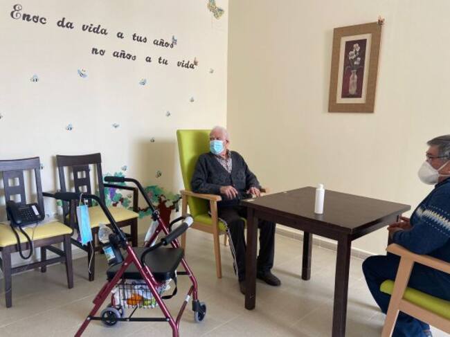 En residente Felipe Jiménez González, de 99 años, junto a su hijo Pedro Jiménez de la Morena en una de las salas habilitadas en la residencia "Virgen de la Encarnación" de Carrión de Calatrava