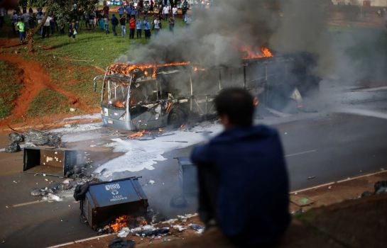 Un hombre observa el autobús, calcinado por los manifestantes en Brasilia.