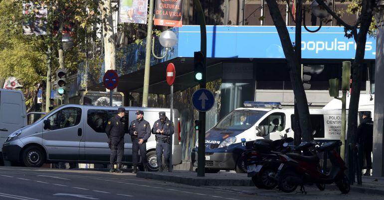 Spanish policeman stand guard outside the Spanish Popular Party's headquarters in Genova street after a man runned his car with two gas cylinders into the political party's building, in Madrid on December 19, 2014. A bankrupt businessman rammed a car cont