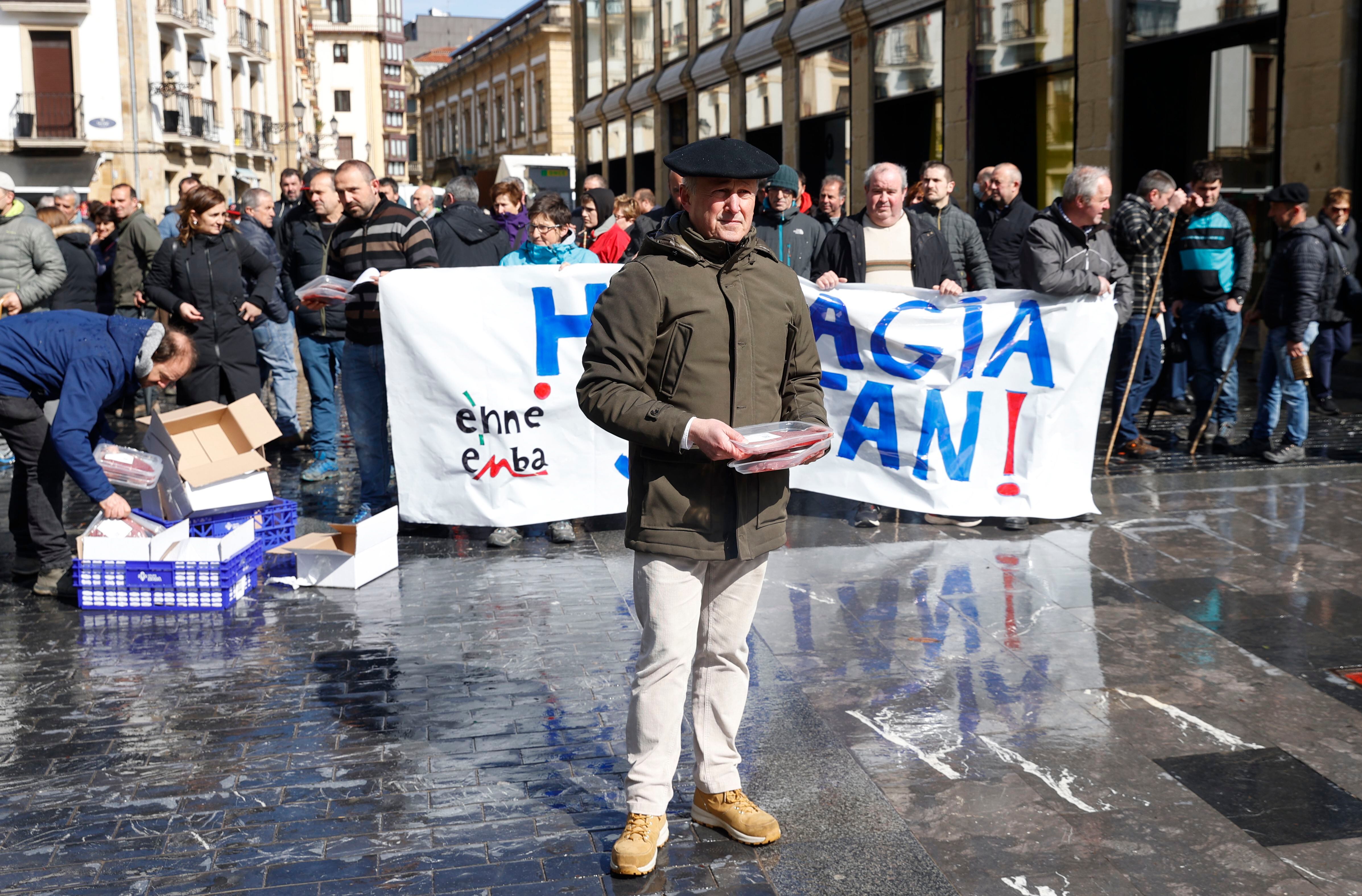 Miembros de los sindicatos agroganaderos ENBA y EHNE han regalado carne a los viandantes durante una concentración este viernes en San Sebastián para denunciar la "crítica situación que vive el sector productor vasco", obligado a vender carne por debajo de sus costes de producción.