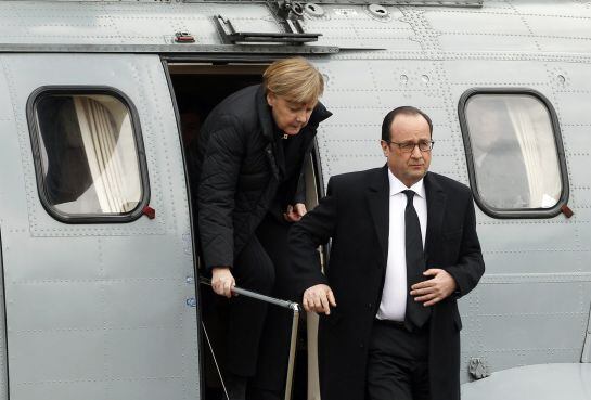 France&#039;s President Francois Hollande and German Chancellor Angela Merkel (L) disembark an helicopter as they arrive in Seyne-les-Alpes March 25, 2015, the day after the air crash of a Germanwings Airbus A320. Hollande, Merkel and Rajoy arrived in the vill