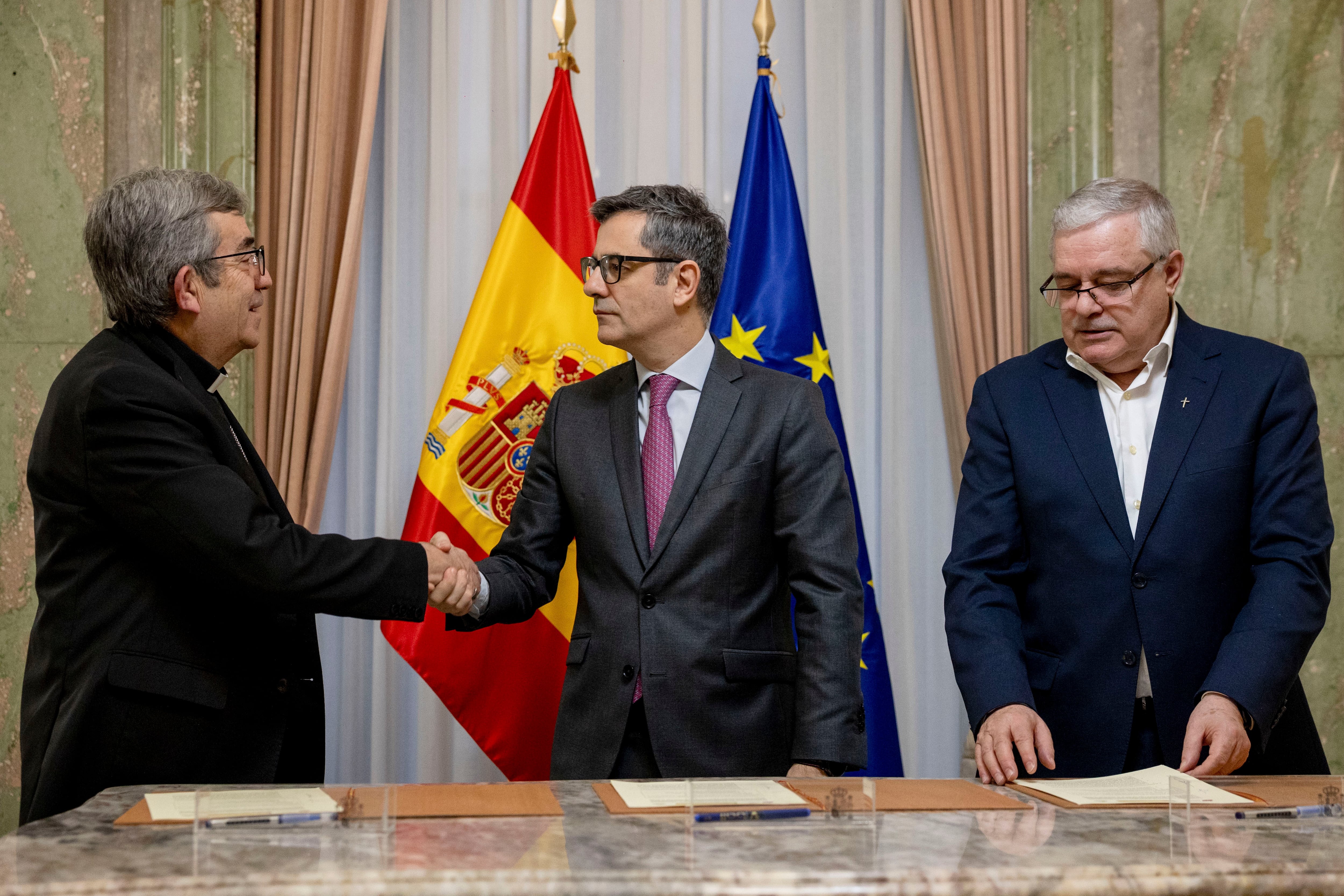 El ministro de la Presidencia, Justicia y Relaciones con las Cortes, Félix Bolaños (c), junto al presidente de la Conferencia Episcopal, Luis Argüello (i), y el presidente de la Conferencia Española de Religiosos (CONFER), Jesús Díaz Sariego (d), durante la firma de un acuerdo para la creación de una nueva vía, a través del Defensor del Pueblo, para la reparación de víctimas de abusos sexuales en el ámbito de la Iglesia católica para las que ya no es posible la vía judicial.