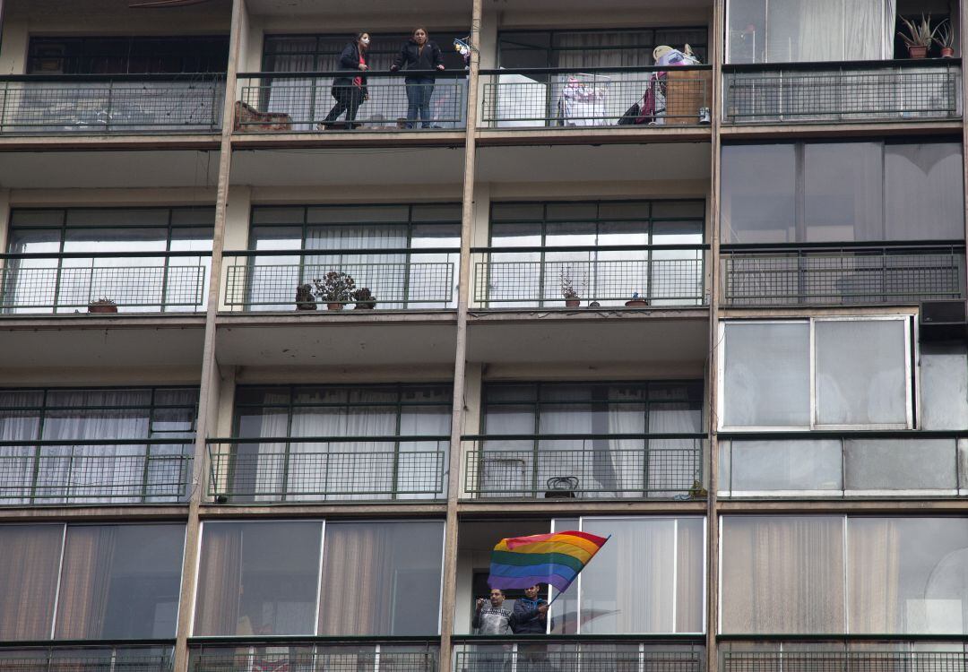 Una pareja muestra una bandera del arco iris desde un balcón durante el Desfile del Orgullo Gay en Santiago de Chile en 2013