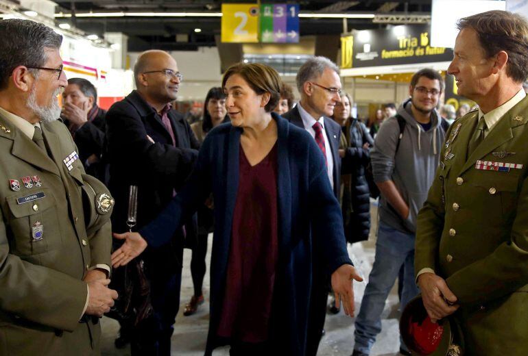 GRA103. BARCELONA, 09-03-2015.- La alcaldesa de Barcelona, Ada Colau (c), conversa con dos mandos militares en el stand que el Ministerio de Defensa ha instalado en la XXVII edición del Salón de la Enseñanza, uno de los 182 expositores que presentan desde