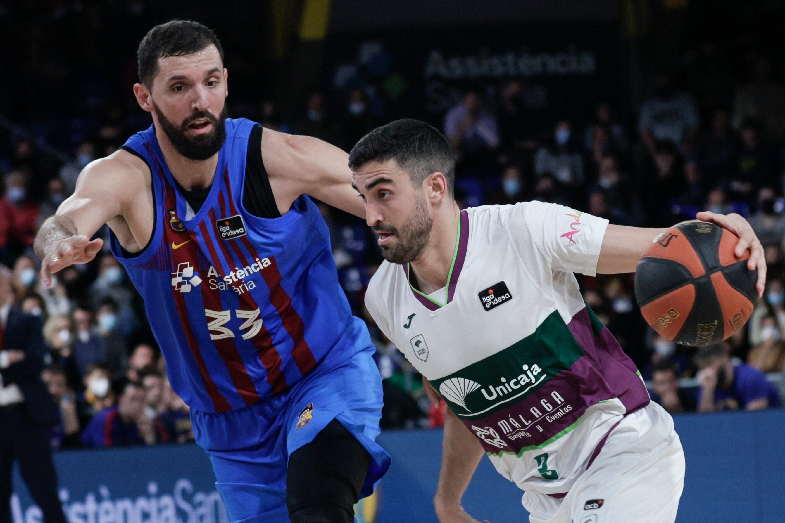 El escolta del Unicaja Jaime Fernández (d) lucha con el ala-pivot del Fc Barcelona Nikola Mirotic (i), durante el partido de la Liga Endesa disputado en el Palau Blaugrana entre el Fc Barcelona y Unicaja. EFE/Quique García