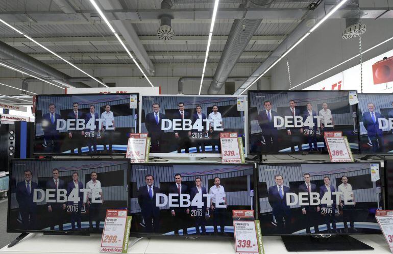 Los cuatro líderes políticos, en las pantallas de una tienda de televisiones antes de comenzar el debate a cuatro