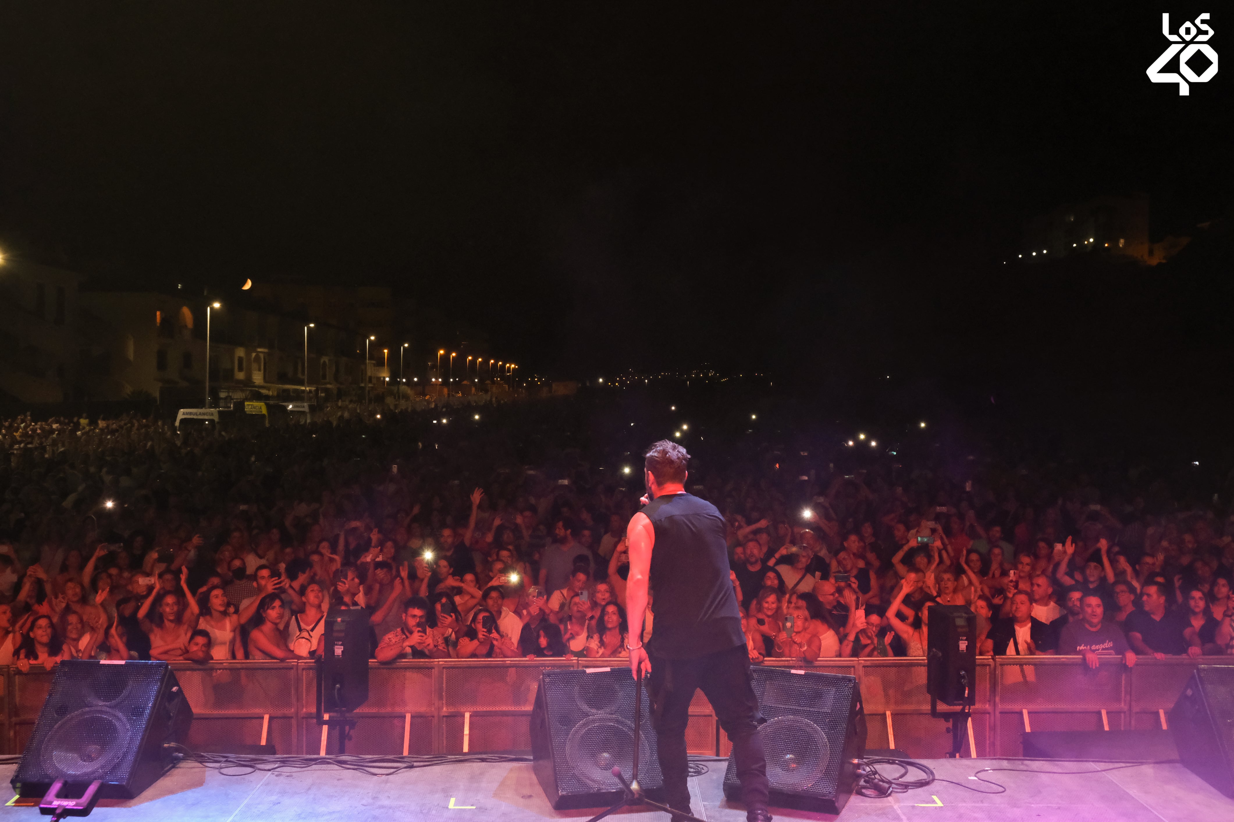 De espaldas, Jordi Sánchez, de OBK, en un momento de su actuación ante las miles de personas que se dieron cita en Puerto de Mazarrón con el concierto de LOS40 Classic