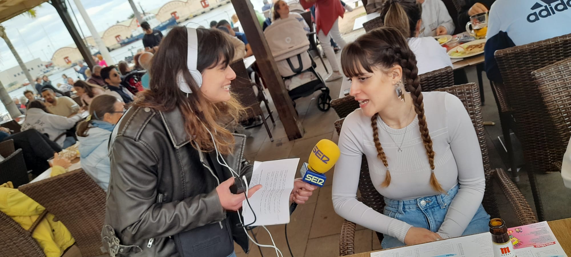 Nuestra compañera Sandra Albert habla con una turista en la Playa de Gandia.