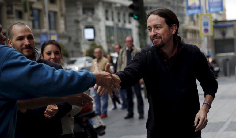 A Movistar worker (R) poses as Pablo Iglesias (C), leader of Spain&#039;s Podemos (We Can) party,  arrives for a rally of Movistar striking workers outside the flagship store of the Spanish telecom group Telefonica in central Madrid, Spain, May 1, 2015. REUTER