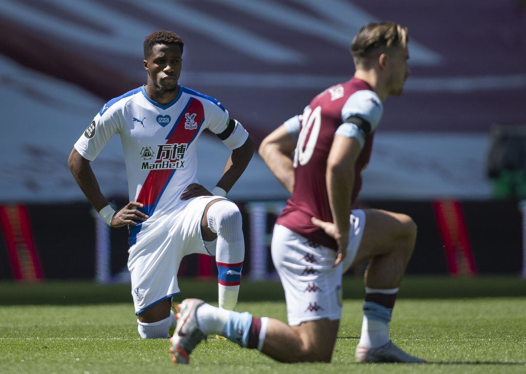 Wilfried Zaha, del Crystal Palace, y Jack Grealish, del Aston Villa, de rodillas en apoyo al movimiento Black Lives Matter.