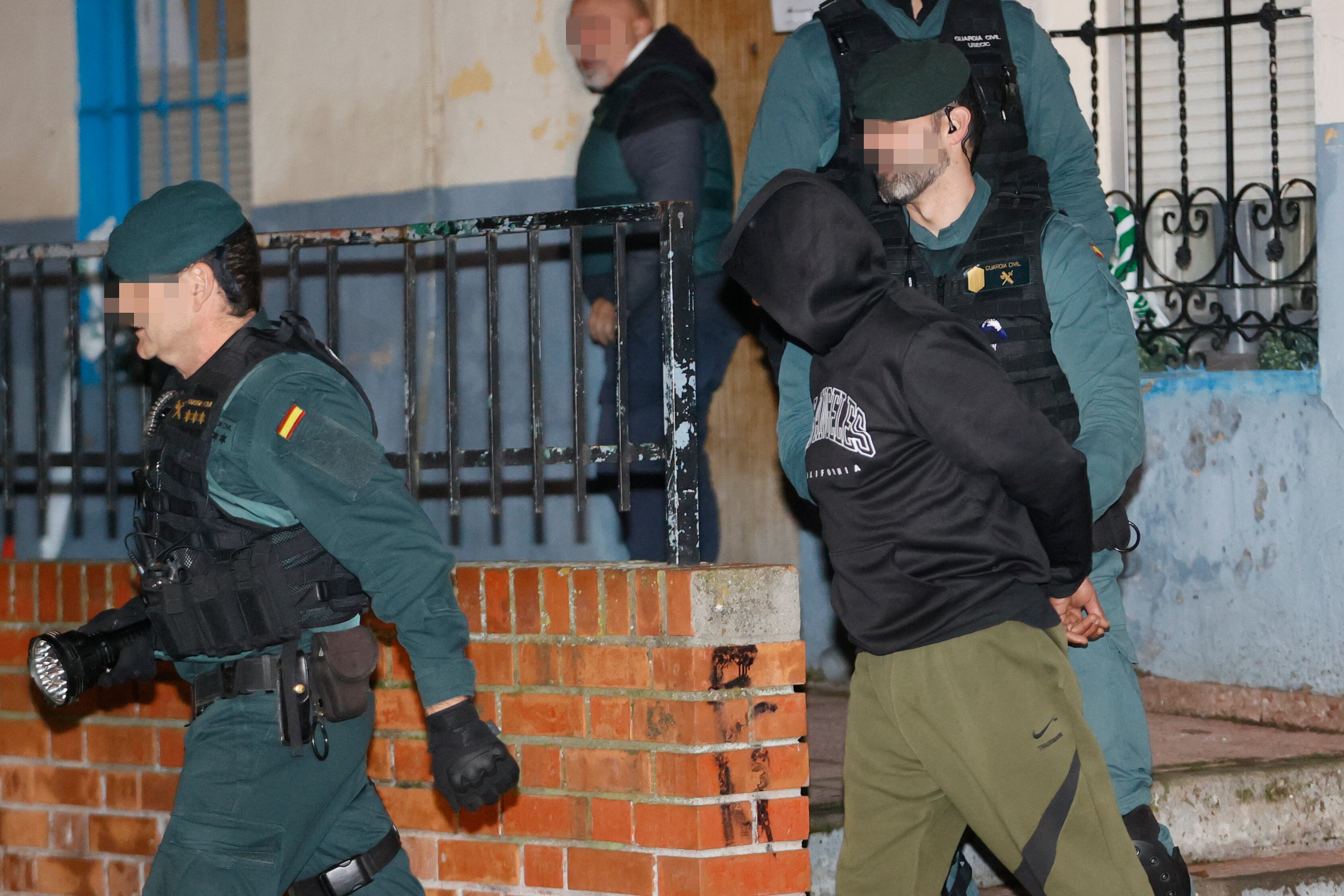 El presunto asesino de tres hermanos en Morata de Tajuña, Dilawar Hussein F.C., sale custodiado por guardias civiles tras el registro de su vivienda en Arganda del Rey.