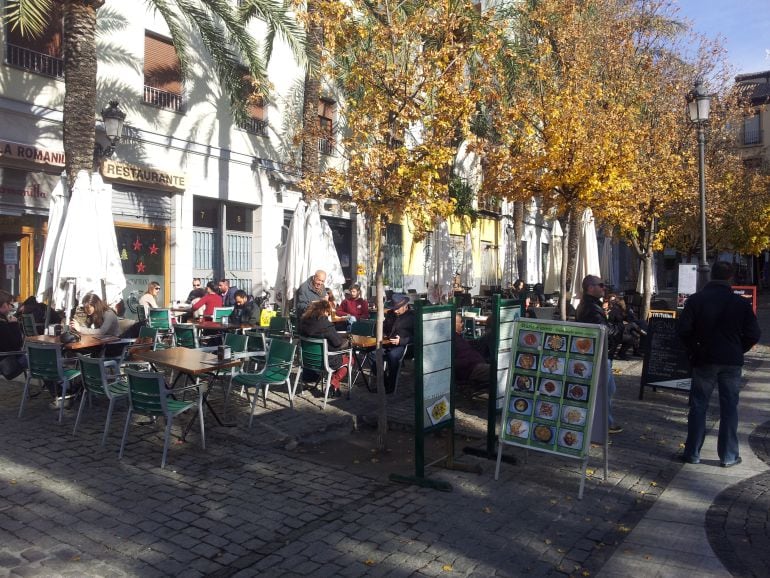 Varios grupos de Turistas desayunan en bares de la Plaza de La Romanilla de Granada.