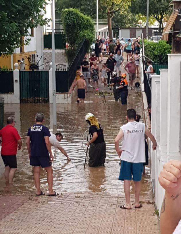 Vecinos de Miralbaida achicando agua tras la granizada caída en Córdoba