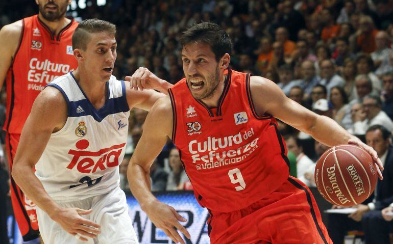 El base belga del Valencia Basket Sam Van Rossom trata de vencer la oposición del escolta estadounidense del Real Madrid Jaycee Carroll, durante el partido de la segunda jornada de la Liga ACB que disputan esta noche en el pabellón Fuente San Luis. 