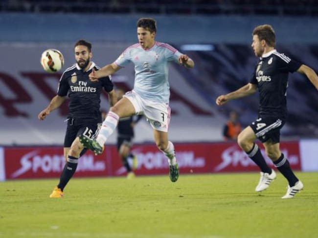 GRA336, VIGO, 26/04/2015.- El delantero del Celta de Vigo Santi Mina (c) lanza a puerta entre Daniel Carvajal (i) y Asier Illarramendi, del Real Madrid, durante el partido correspondiente a la jornada trigésimo tercera de Liga en Primera División que se d