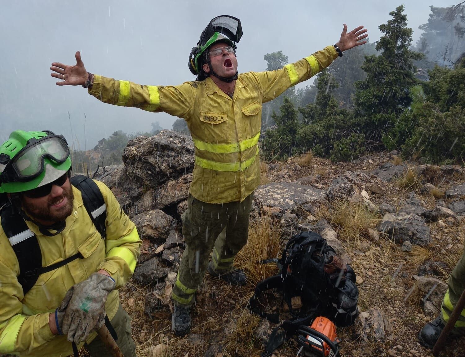 Bomberos forestales celebran la llegada de la lluvia en la zona del incendio de Coto Ríos, en Santiago-Pontones