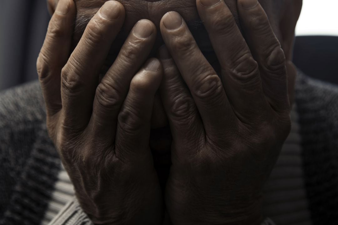 Un hombre se tapa la cara con las manos en un gesto de impotencia.