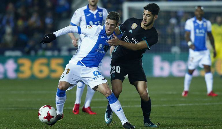 Marco Asensio (d) del Real Madrid C.F. lucha con Ruben Perez del C.D. Leganes durante el partido de Copa de este jueves.