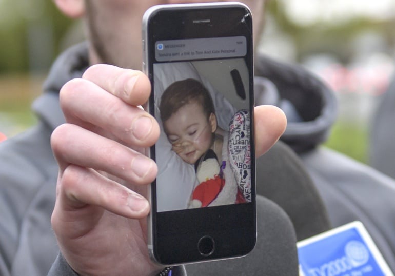 Tom Evans, padre de Alfie Evans, muestra la foto de su bebé