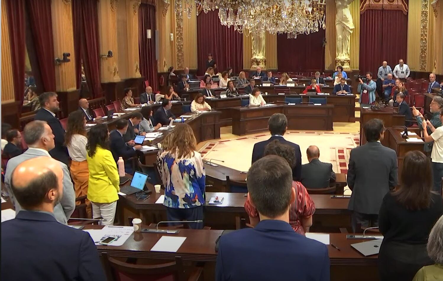 Imagen del minuto de silencio a instancias del PSIB con la bancada de la izquierda en pie y el resto de la cámara sentada