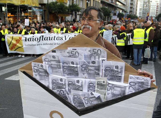 Un hombre con un sobre lleno de billetes en referencia al 'caso Bárcenas' en la manifestación de Valencia.