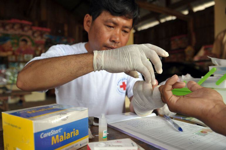 Un voluntario de la Cruz Roja realiza el test de la malaria