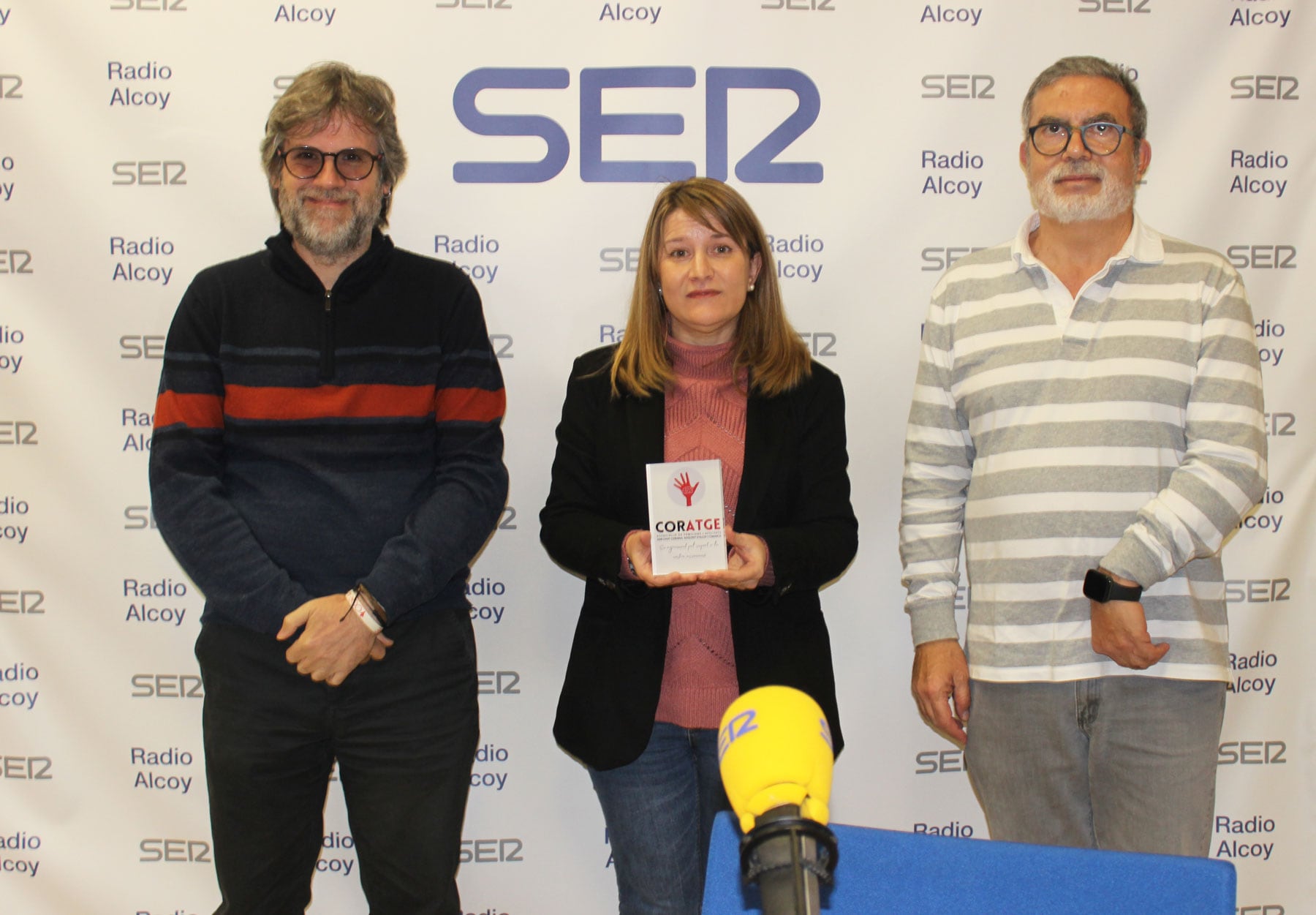 Àngel Lluís Ferrando, Celia Úbeda i Rafa Hernández, amb el record que ha entregat Coratge a Radio Alcoy