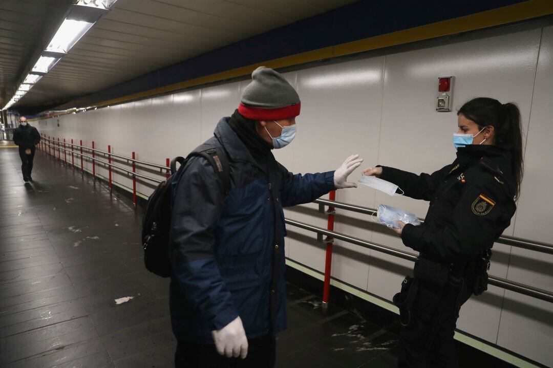 Una agente reparte esta mañana mascarillas entre los usuarios del metro de Madrid. 