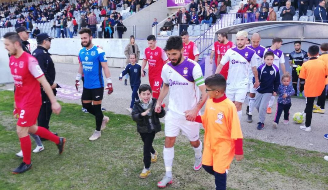 Los jugadores de Real Jaén y Torreperogil salen al campo en el partido de liga disputado este año.