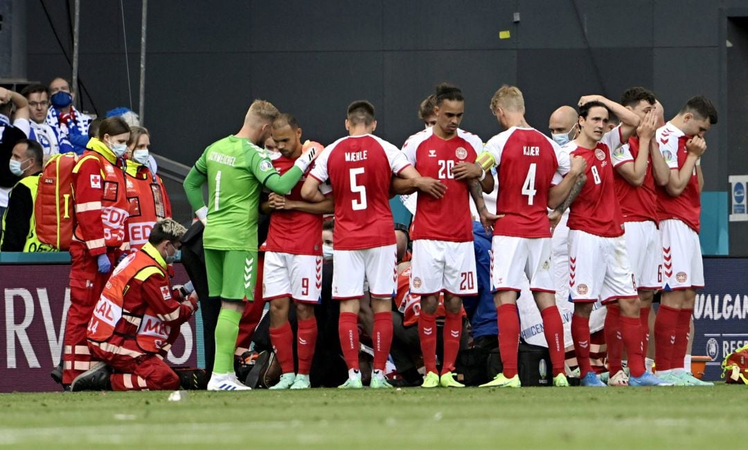 Los jugadores de la selección danesa hacen un corro para evitar que las cámaras graben a Eriksen.